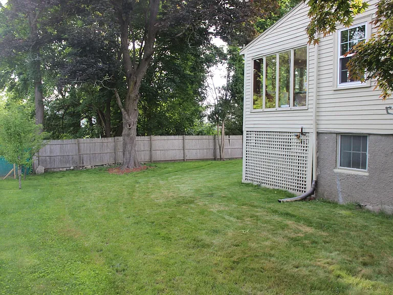 Left side view of the house. There is additional Closed storage under the sunroom( can be seen as shutter wall in pic)