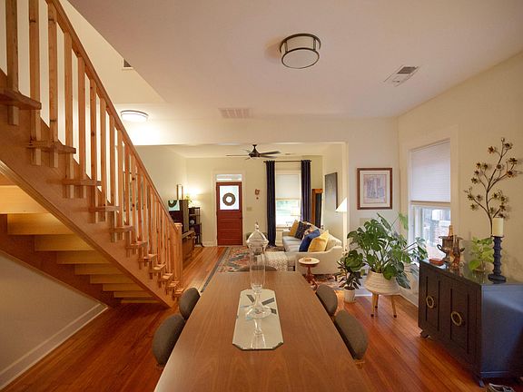 View from kitchen into dining and living areas. Red front door leads to front porch.
