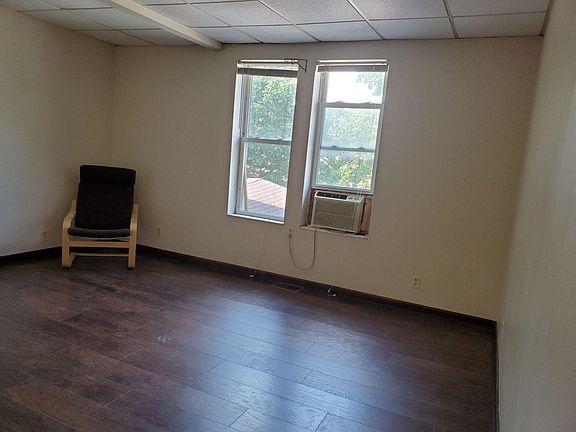 front windows from the inside looking toward street. Newer laminate floor. chair is not with apt., but AC stays