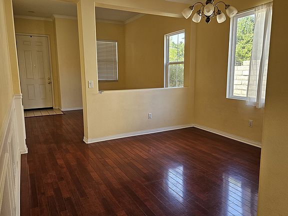 Entryway, living room, dining room, wall paneling/framing and crown molding. (Empty)