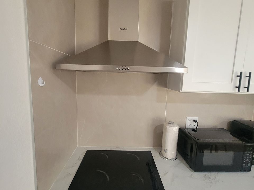 The kitchen includes a refrigerator, coffee maker, extractor hood and basic amenities.