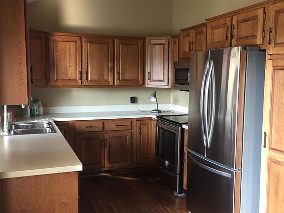 Kitchen with vaulted ceiling, hardwood floor, and newer appliances