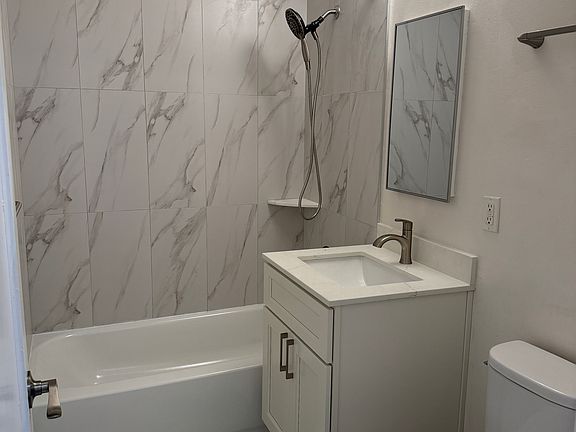Newer remodeled bathroom with shower over bathtub. Porcelain tile floor.