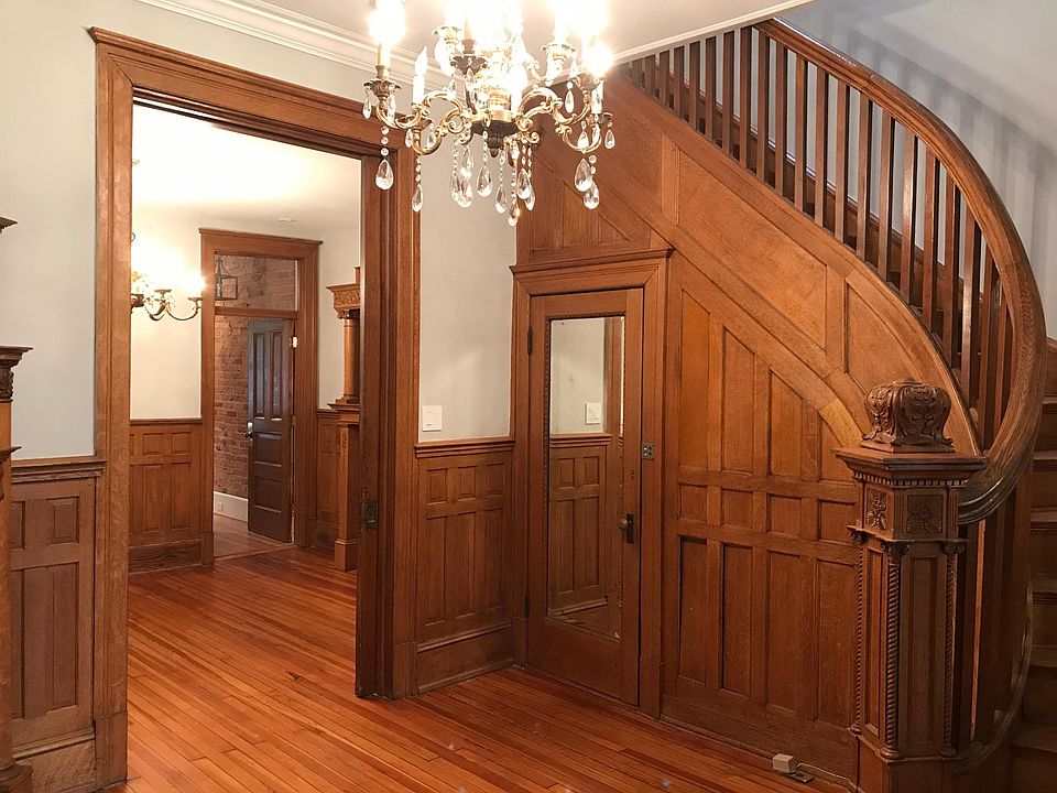 living space with original woodwork that moves into a formal dining room and kitchen. extra storage space under the staircase.