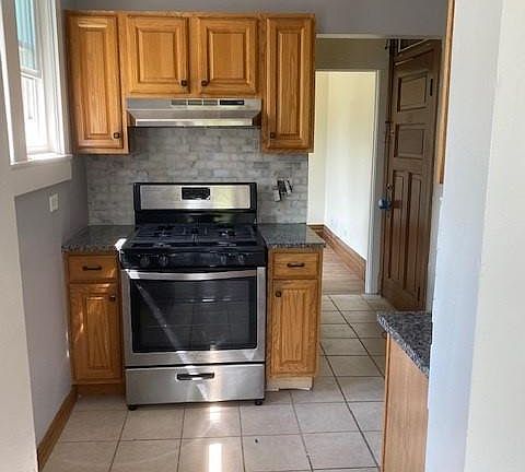 Kitchen with new appliances, granite countertops and marble backsplash