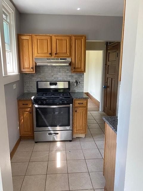 Kitchen with new appliances, granite countertops and marble backsplash