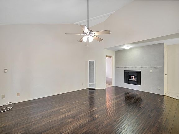 Living Room with Vaulted Ceilings, Fire Place, Heater, Air Conditioner and Ceiling Fan