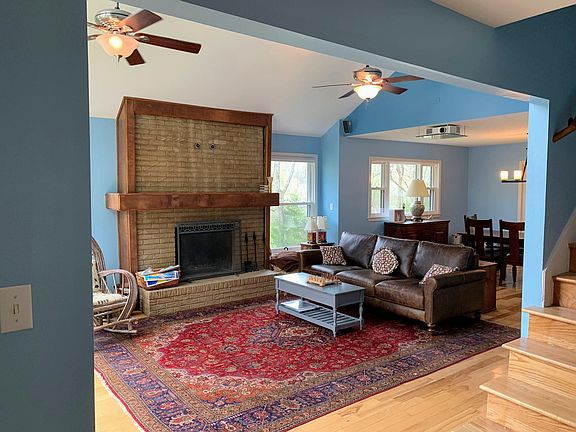 Looking to your left from that entrance is a warm, open style living room and dining space. The projector mounted on the ceiling above the couch is a bonus.