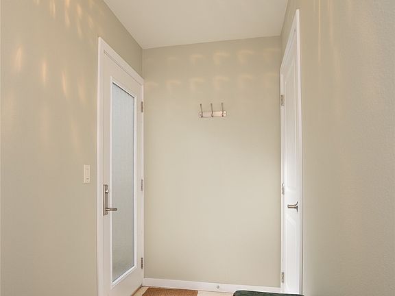 Travertine tiled entryway with coat closet.>