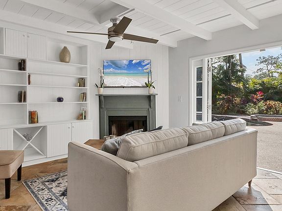 Living area with fireplace that leads to pool/backyard.