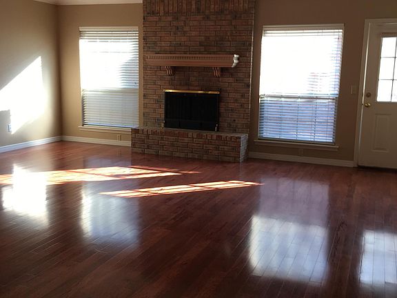 Living room with brick, wood burning fireplace.