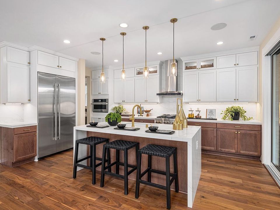 Gourmet kitchen features an island with waterfall edge