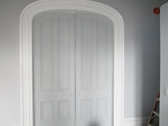 massive paneled pocket doors separating the living room from the bedroom