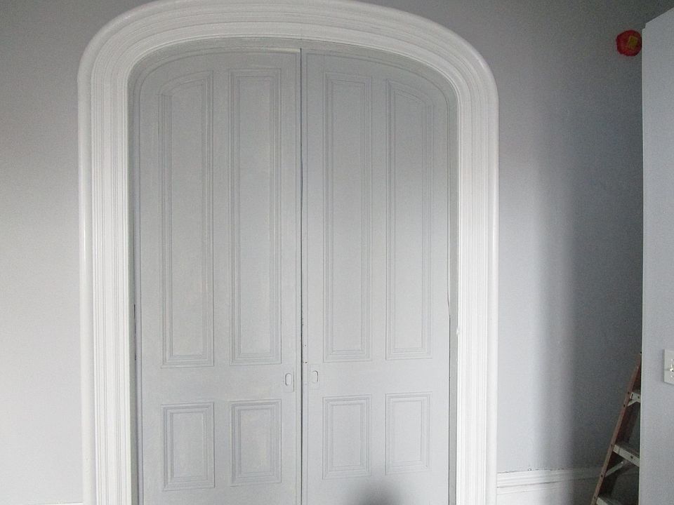 massive paneled pocket doors separating the living room from the bedroom