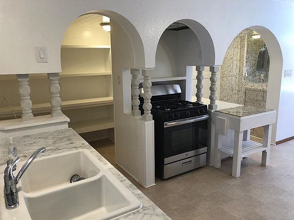 EXPANSIVE KITCHEN INCLUDES A CUSTOM-SHELVED WALK-IN PANTRY, QUARTZ COUNTERTOPS, NEW GAS RANGE, AND LOTS OF LIGHT!