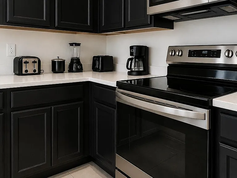 Efficient L-shaped kitchen with ample cabinetry, generous counter space, and stainless steel range and microwave.