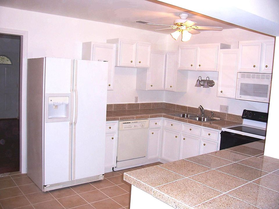 Big kitchen with granite countertops and tile floor, over the range microwave