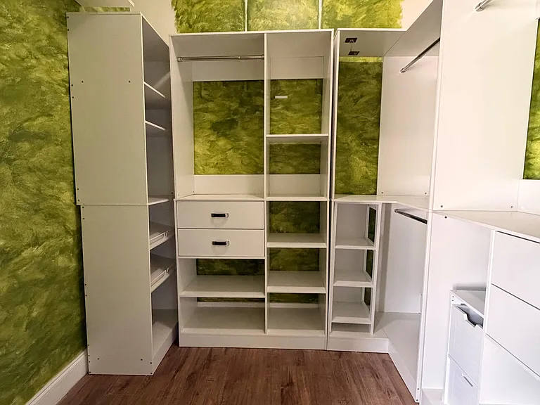 Custom walk-in closet with built-in shelving, drawers, and hanging rods for efficient, organized storage.