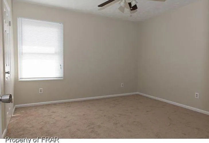 The second bedroom has an energy-efficient ceiling fan, freshly painted walls, shampooed carpet, new blinds, and a bifold closet door.
