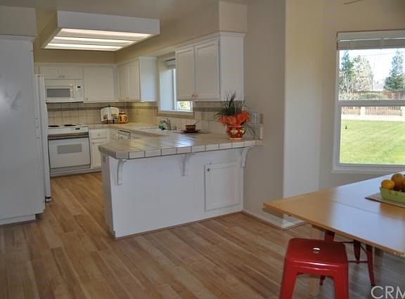 Light and bright open kitchen with breakfast nook and hardwood floors.