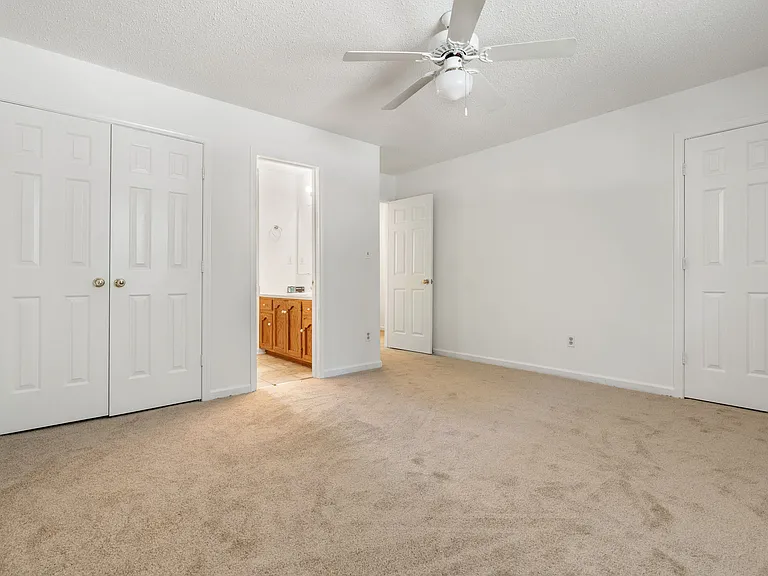 Primary suite featuring double closets, en-suite bath access, and plenty of space for a king-size bed