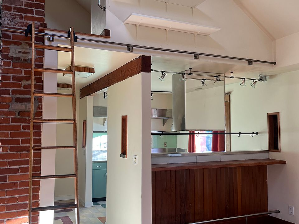 living room has built-in bar looking into kitchen. Moveable ladder into loft can also access high up shelves above bar. Perfect for plants, jars, etc. This is natural light.
