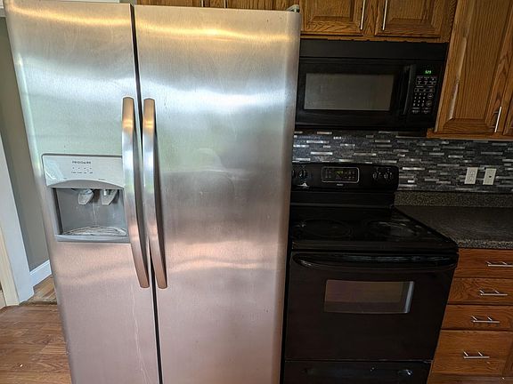 Side by side fridge with icemaker, electric stove and microwave