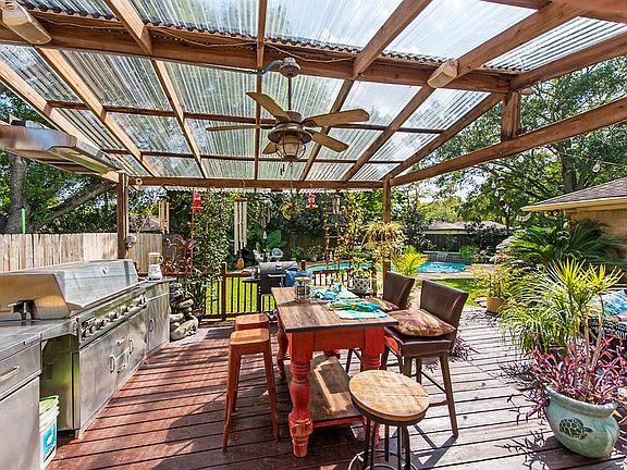 Covered outdoor kitchen is complete with plenty of counterspace, sink and even the dining table !