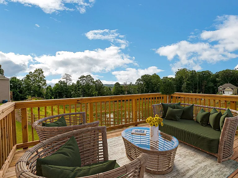 Private deck styled with wicker seating and a sleek glass-top table.