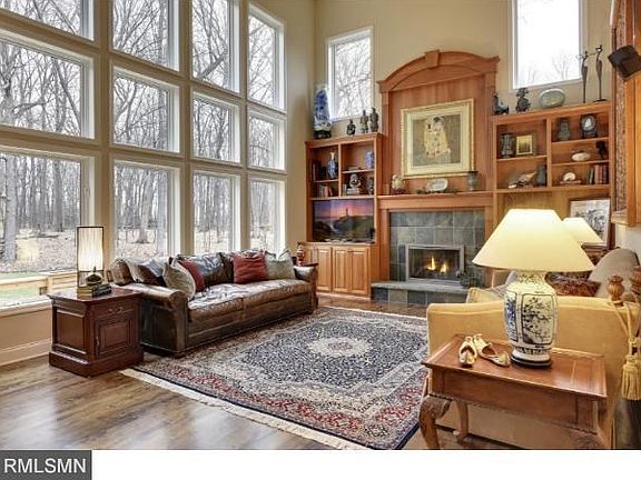 Dramatic 2-story vaulted family room with floor to ceiling windows overlooking the backyard and wooded lot.