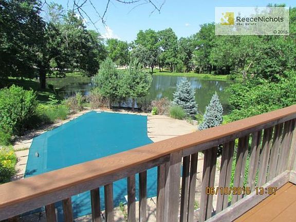 Deck overlooks pool area and community lake