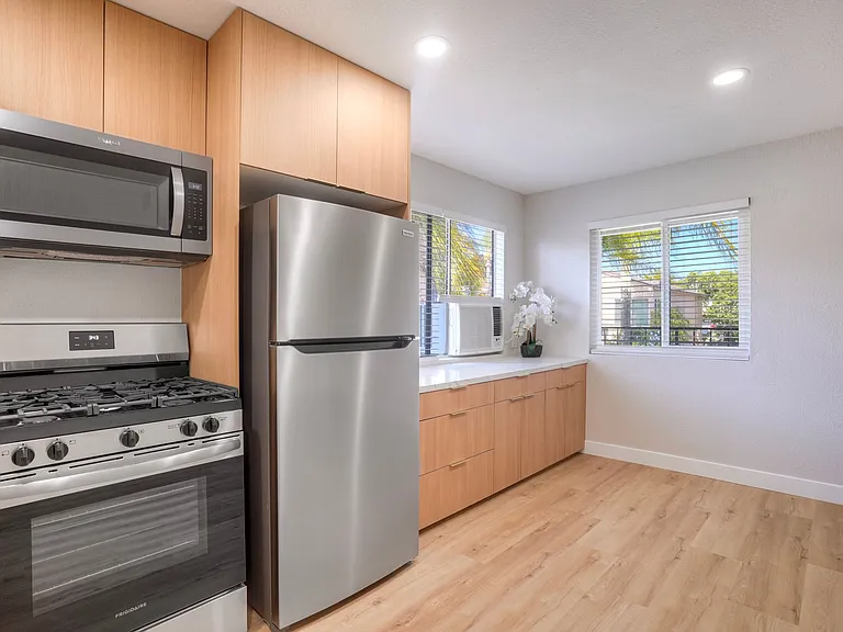 Flat Euro cabinets with designer handles and stainless steel appliances with additional counter and cabinets