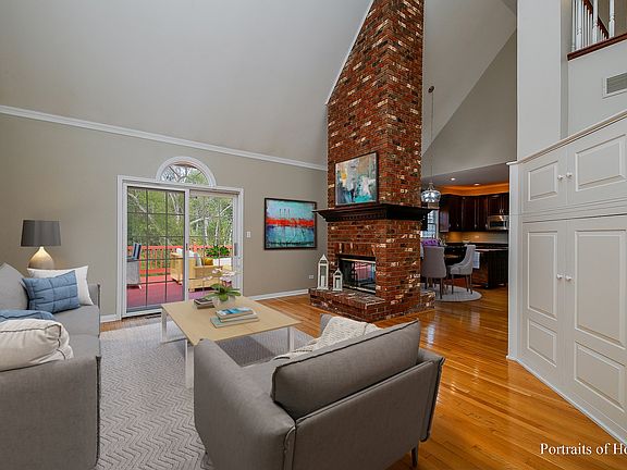 Family Room with media built-in, 2-story, double-sided fireplace and sliding door exit to deck with 