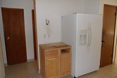 Right side of kitchen has fridge and is missing counter top