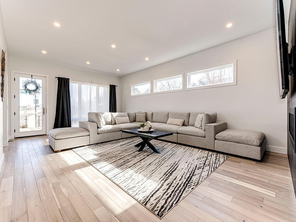 Living Room with large sectional and two-sided fireplace and 85-inch Smart TV.