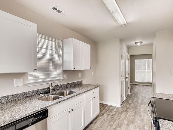 Undermount stainless sink at kitchen window. Pantry closet in hall between kitchen and front room.