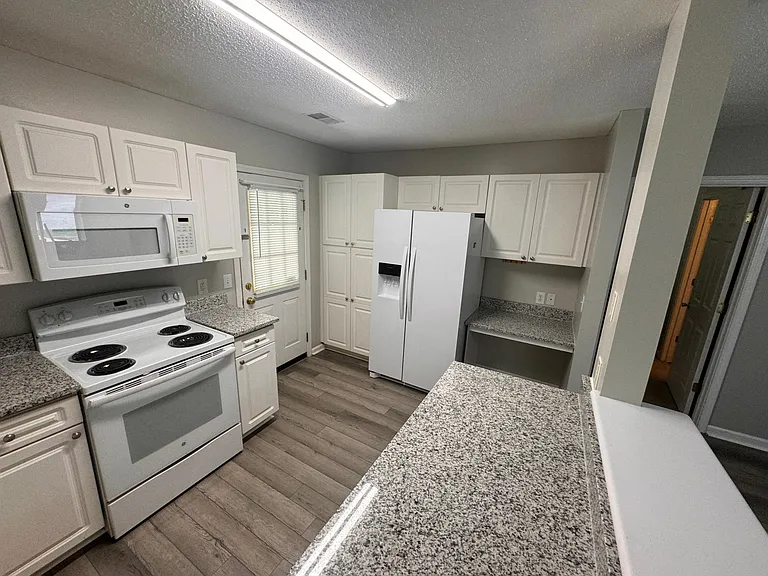 New Kitchen Granite Countertops- Bar to the right also replaced after this photo. Nice new side by side refrigerator with ice and water on door