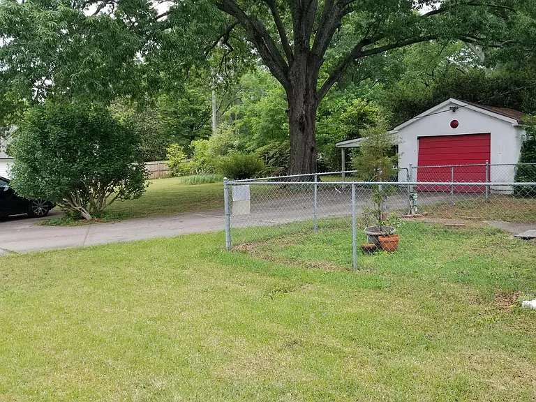 Small fenced yard with detached garage, carport