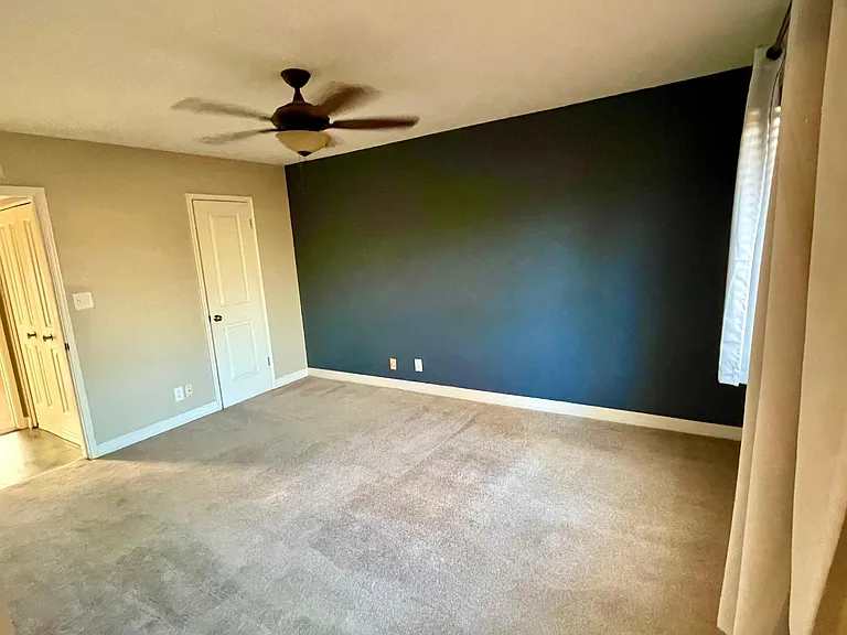 large master bedroom with walk-in closet blinds and blackout curtains