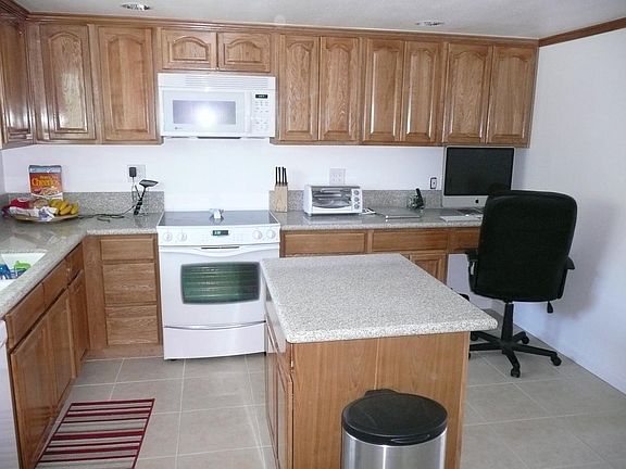 Kitchen from entrance hall. Appliances have been replaced with similar. Gas range installed. (please note, prior tenant's content items in photo not included with home)