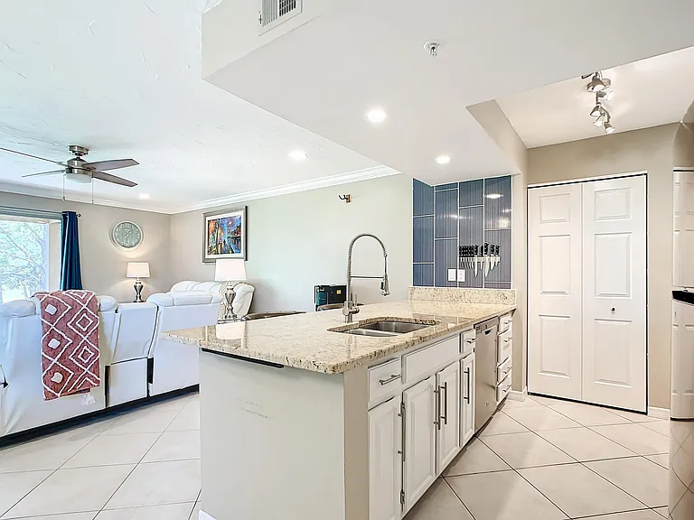 White kitchen with polished granite stone oversized counter-top.