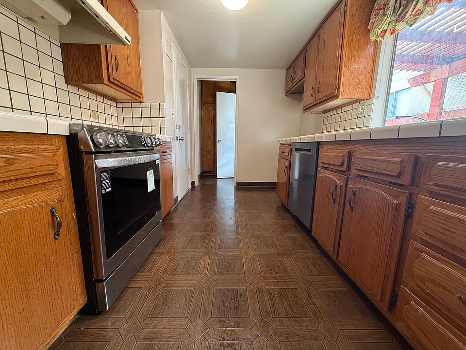 Efficient galley kitchen with brand-new built-in appliances, abundant cabinetry and natural light.