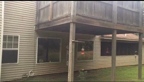 Back of home showing windows and upstairs deck.