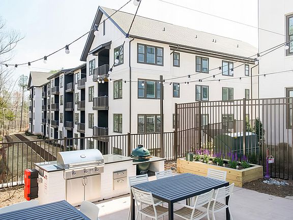 Spacious outdoor grilling station with two grills and herb planters