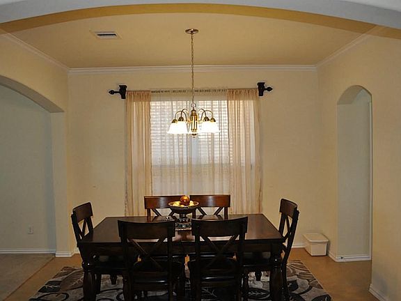 Formal Dining includes crown molding, chandelier & tile flooring.