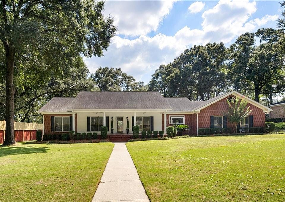 Ranch-style home with a front yard and a porch