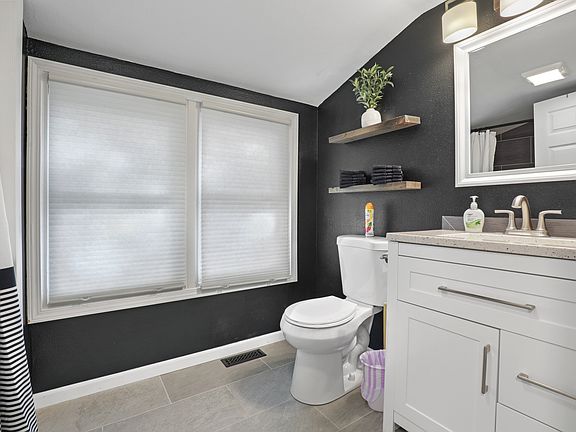 Bathroom off the kitchen, bath tub, tile floors and shower.