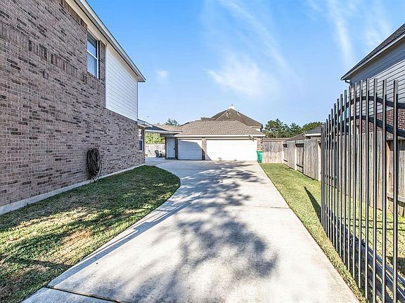 A gated driveway leads up to a detached 3-car garage that is decked for extra storage and equipped with a generator switch transfer.
