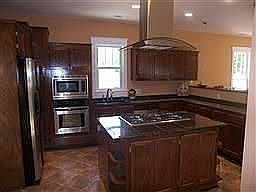 Gourmet Kitchen w St. St. Appl., granite tile contrs, island, sl tile floors.