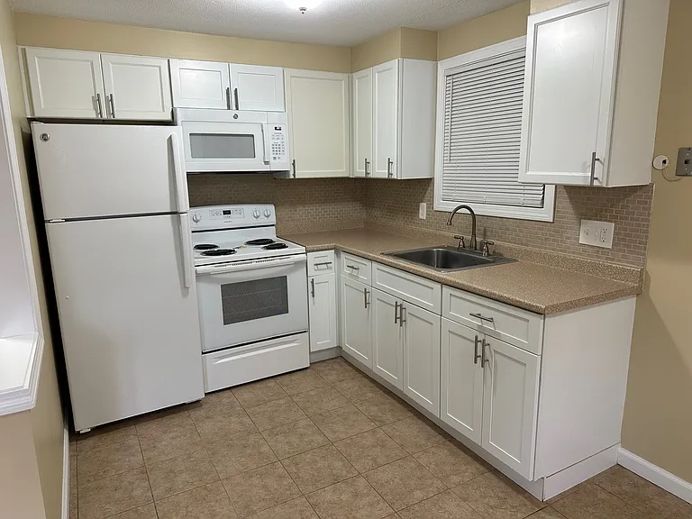 New Kitchen with white Shaker cabinets, tile flooring, newer appliances